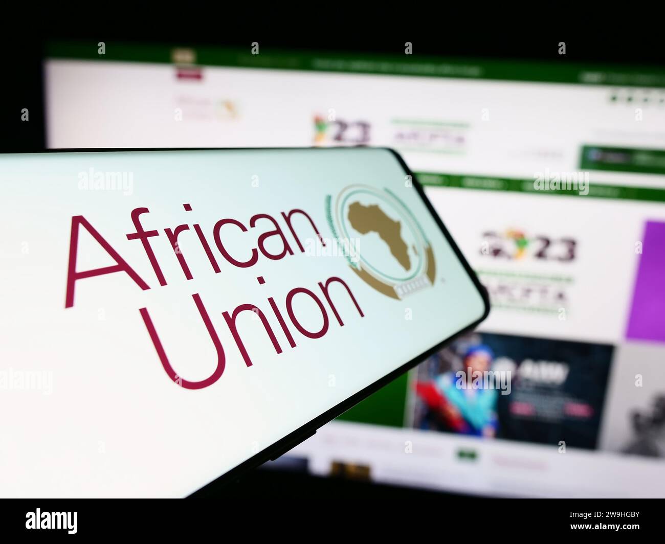 Cellphone with logo of continental organization African Union (AU) in front of website. Focus on center-left of phone display. Stock Photo