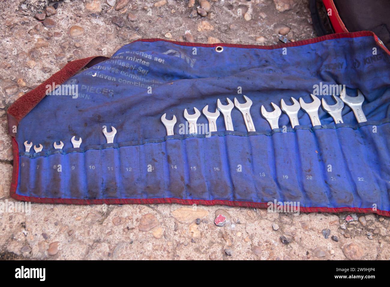 Combination wrenches with rings and open ends lined up in blue plastic case in mechanical