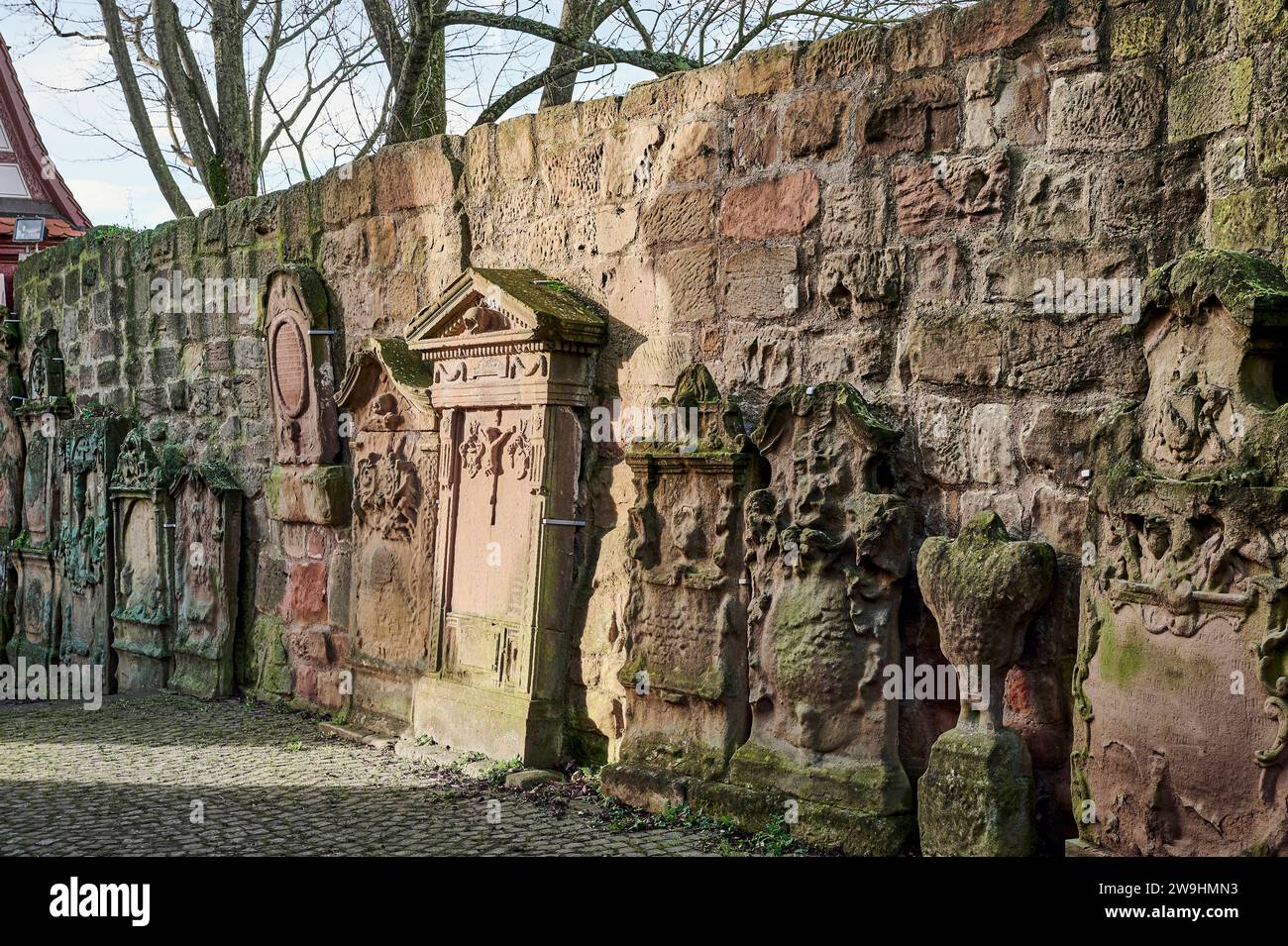 Historische Kirchenmauer mit Grabplatten an der Johanneskirche der