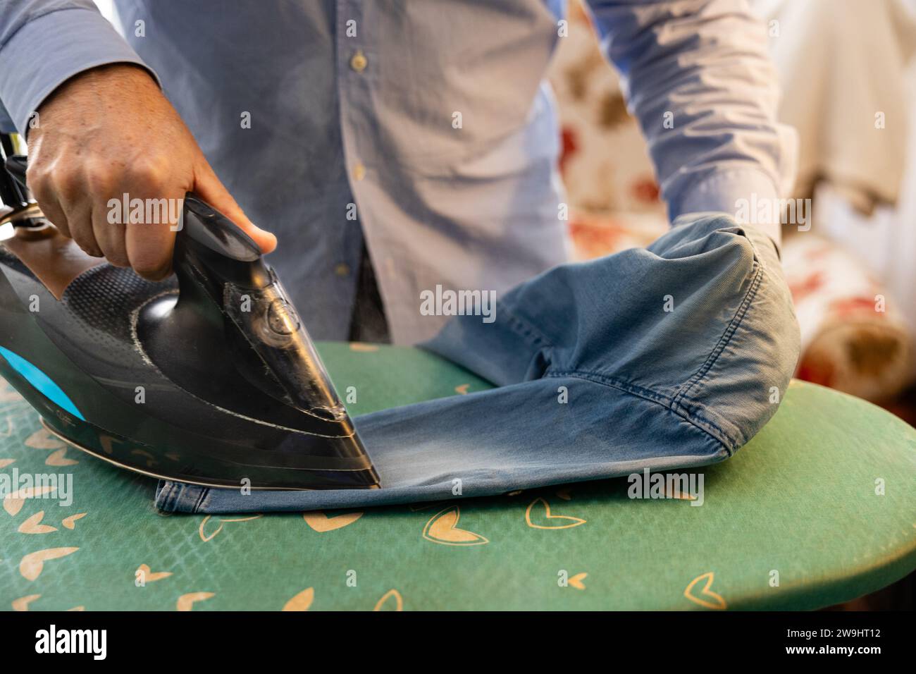 Close up of an older man's hands ironing clothes at home Stock Photo