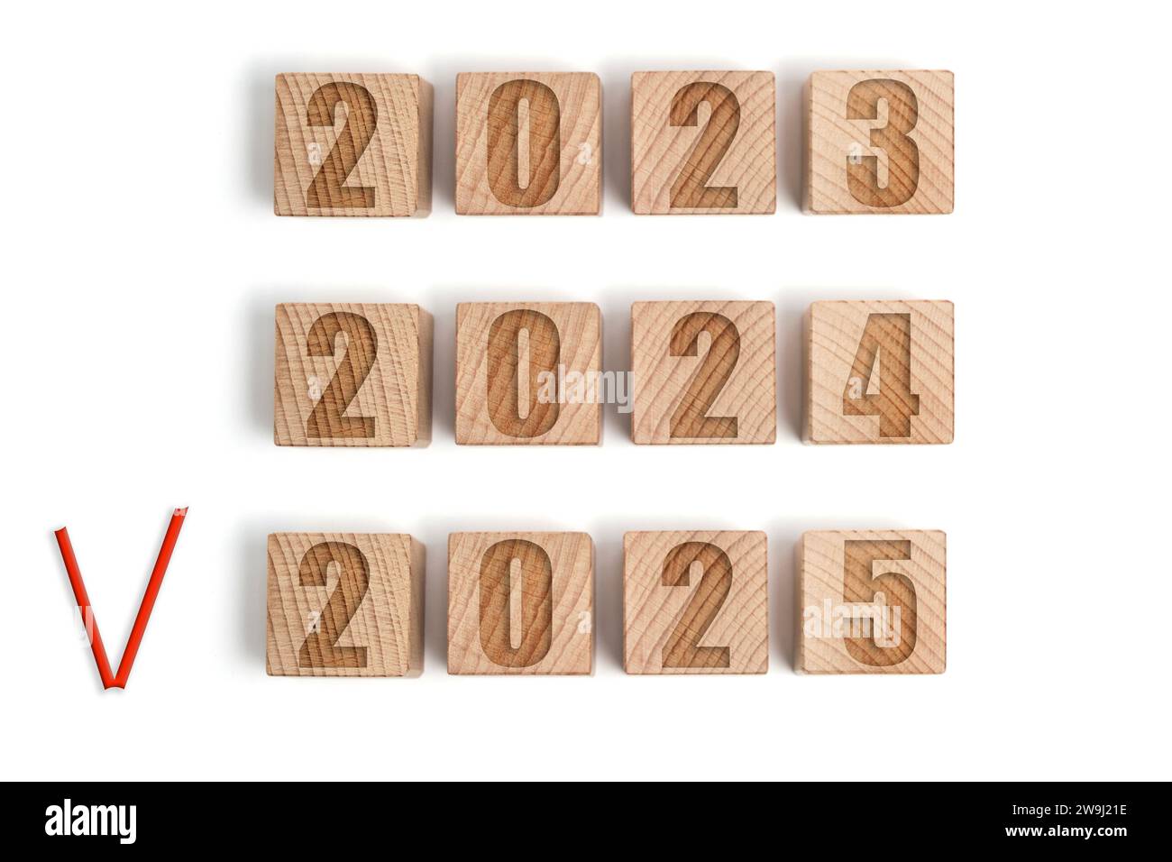 Wooden cubes with the years 2023,2024 and 2025 marked with a red check mark Stock Photo