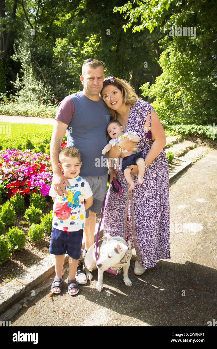 Family posing standing composed of parents, two children and a dog ...