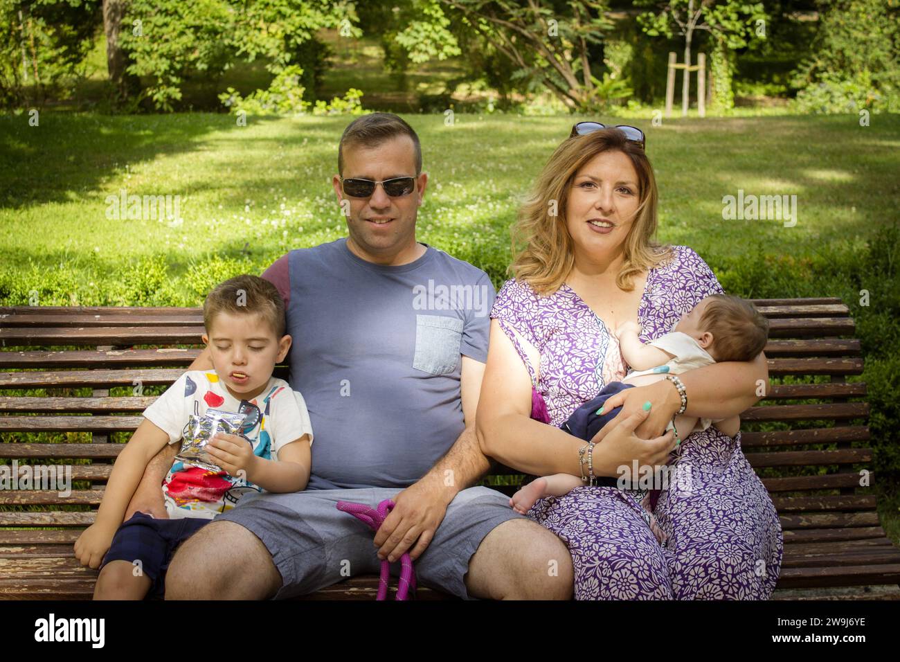Family sitting on a bench with their stanford dog Stock Photo