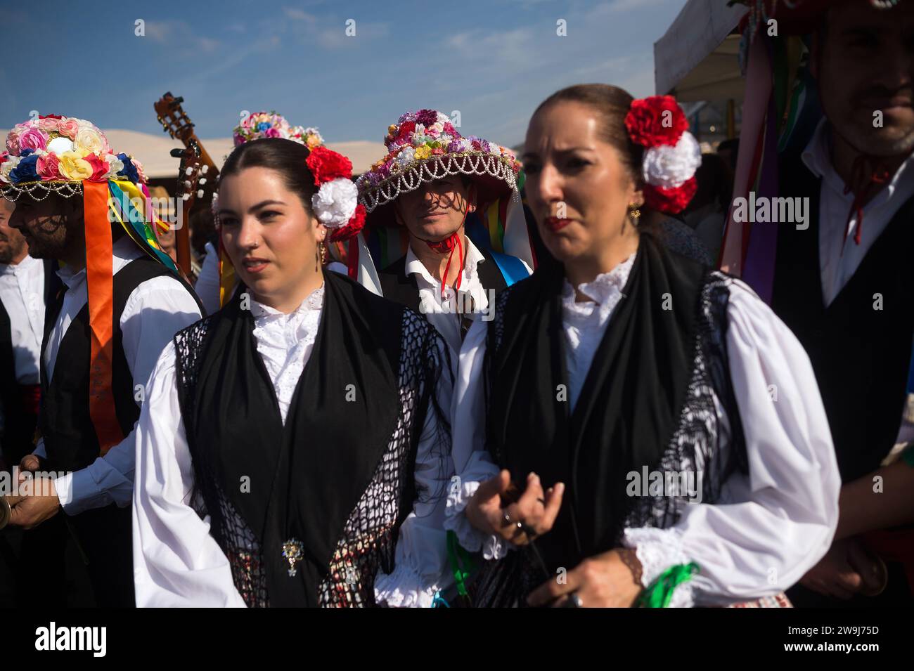 Women and men dressed in traditional costumes attend the festival. The