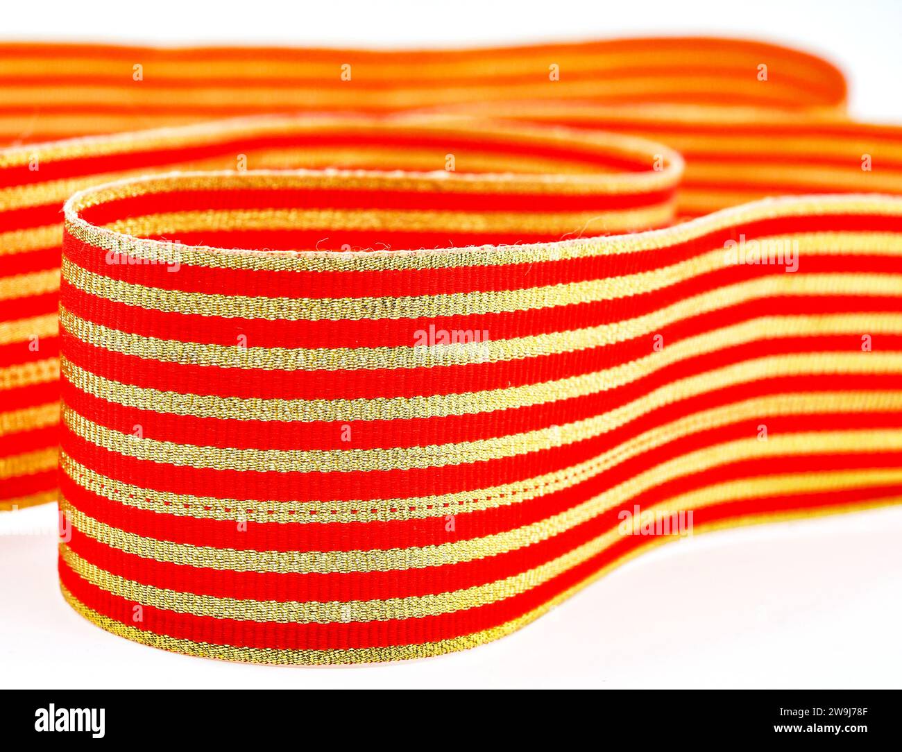 Close up view of red and gold coloured ribbon tape. Backgrounds. No people. Stock Photo