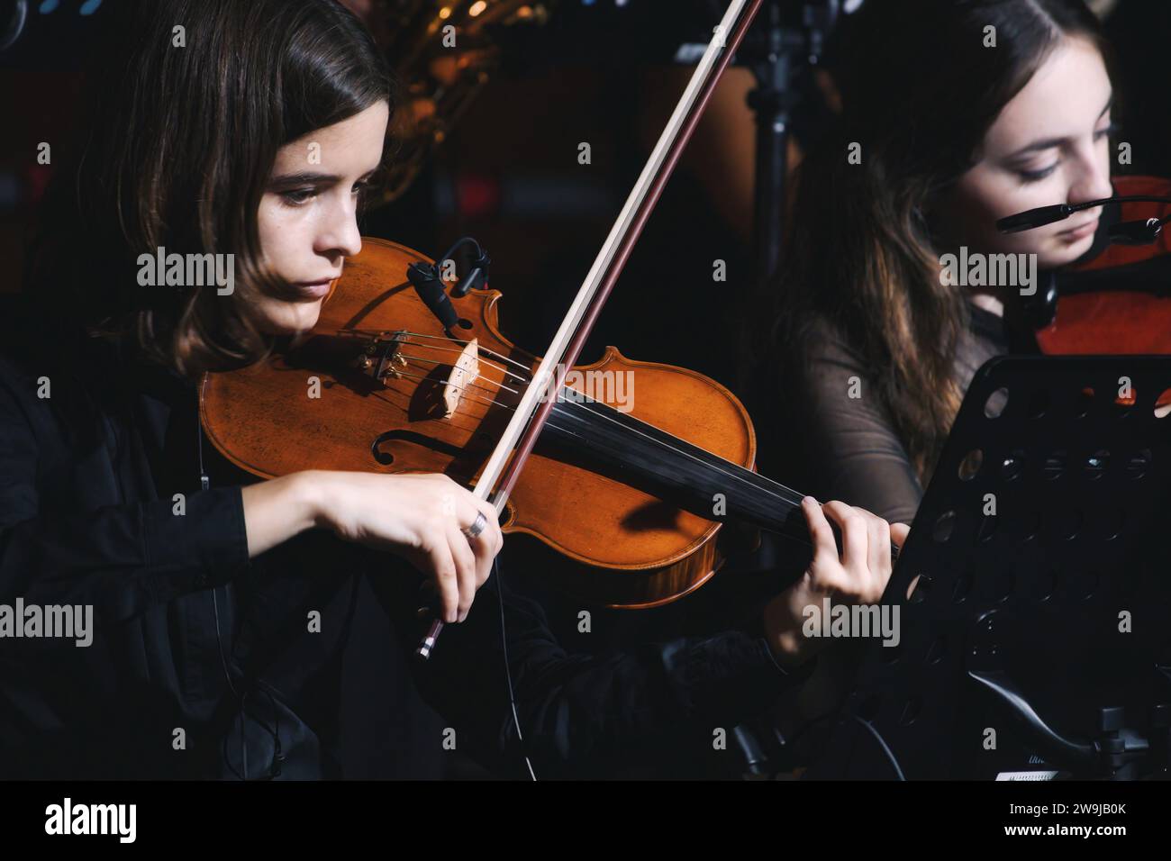 Valletta, Malta - Oct 07 2023: Close-up shot of a professional young female violinist girl in a classical music orchestra at an open-air theatre conce Stock Photo