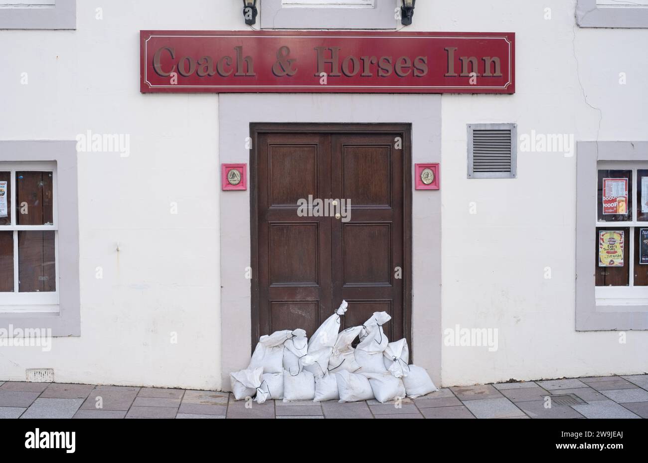 Wide view of sandbags stacked at the front door of the Coach and Horses Inn, Whitesands, Dumfries, Scotland, in preparation for flooding. Stock Photo