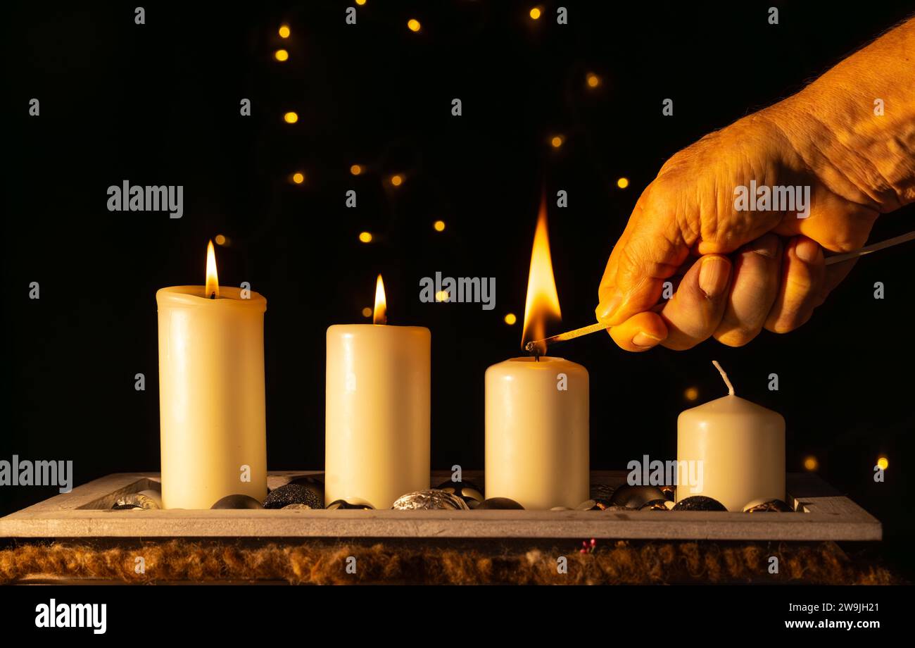 Light the third advent candle with a matchstick stock photo alamy