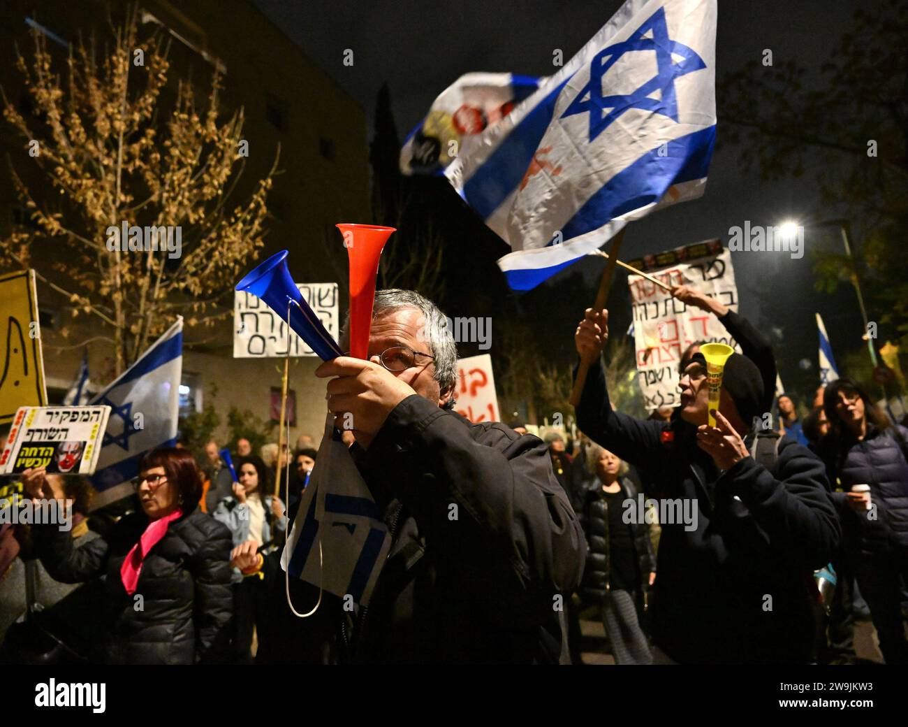 Jerusalem, Israel. 28th Dec, 2023. A man blows horn at a protest