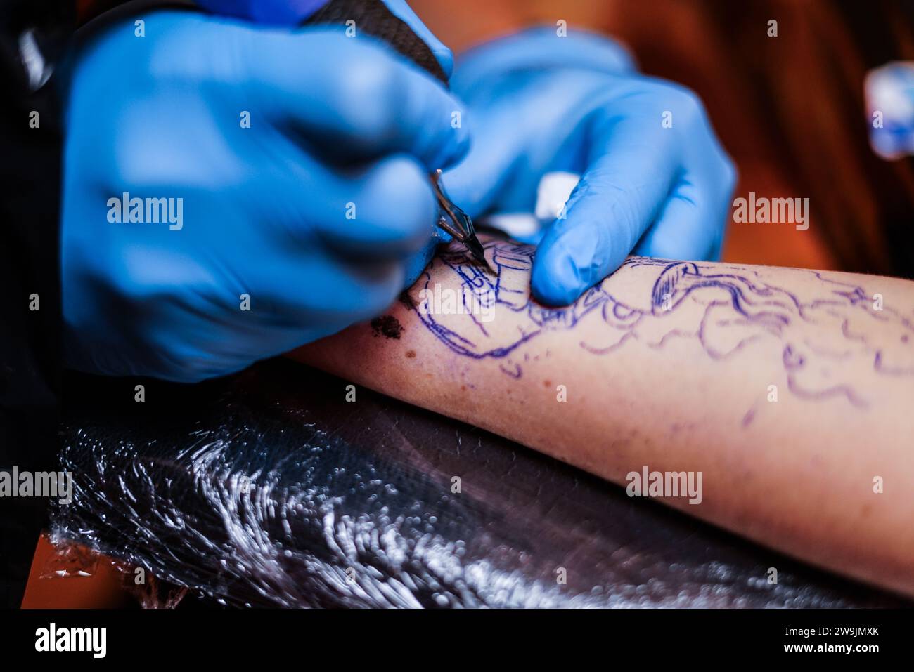 Making tattoo in the tattoo studio. Stock Photo