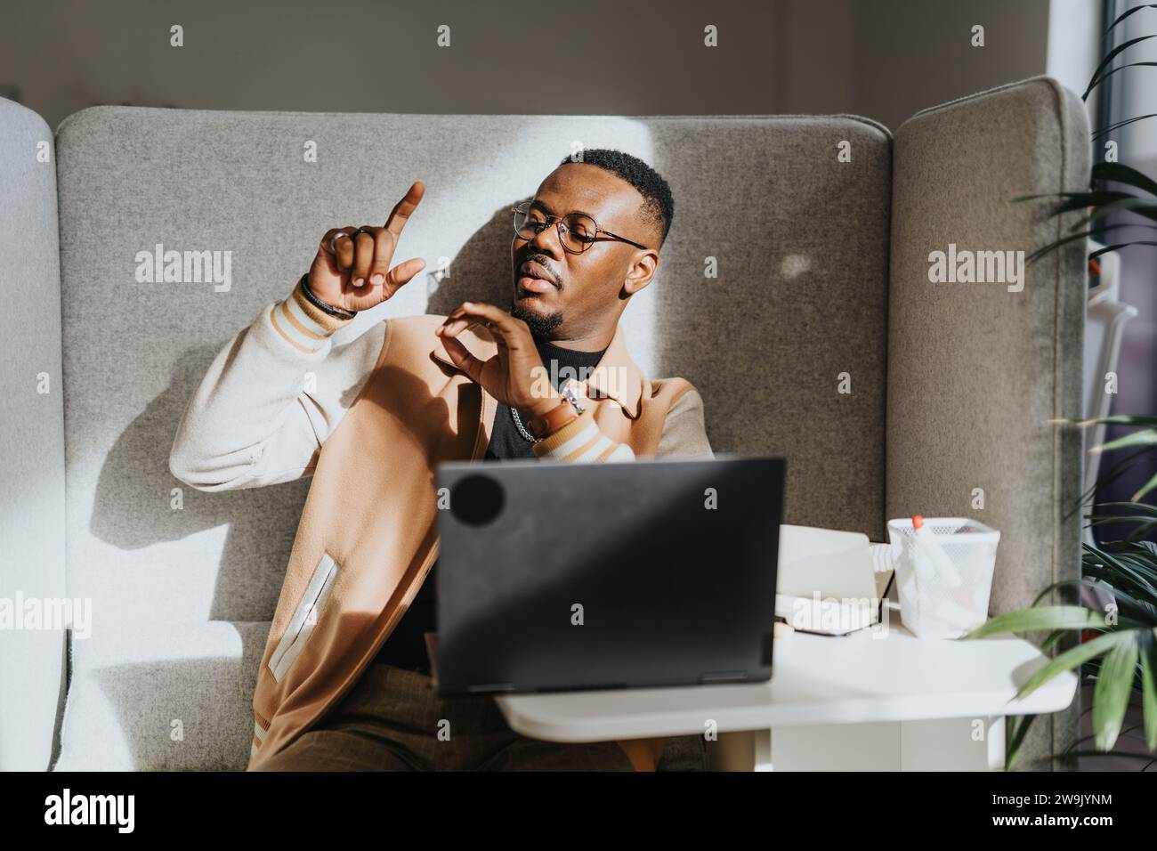 Handsome, black, male employee gestures with arms while explaining ...