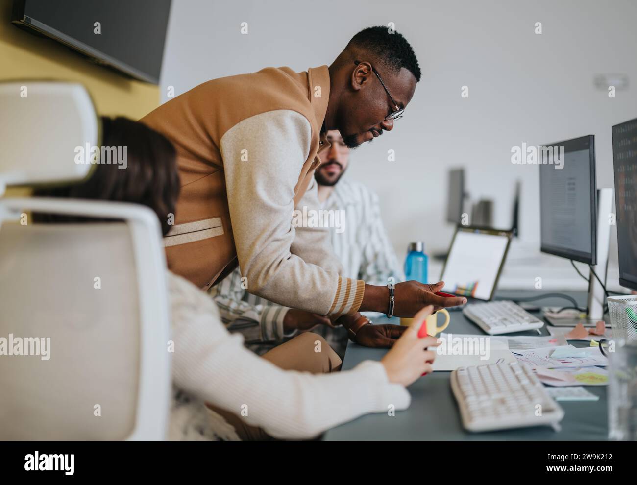 Multicultural employees collaborating in a creative office, discussing ...