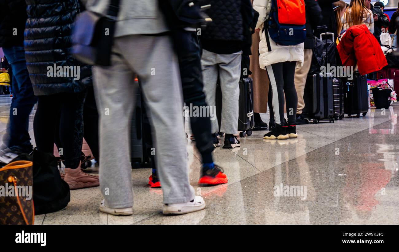 Airline passengers lining up for a delayed flight at the airport as holiday traffic was snarled with long queues and multiple cancelled flights Stock Photo