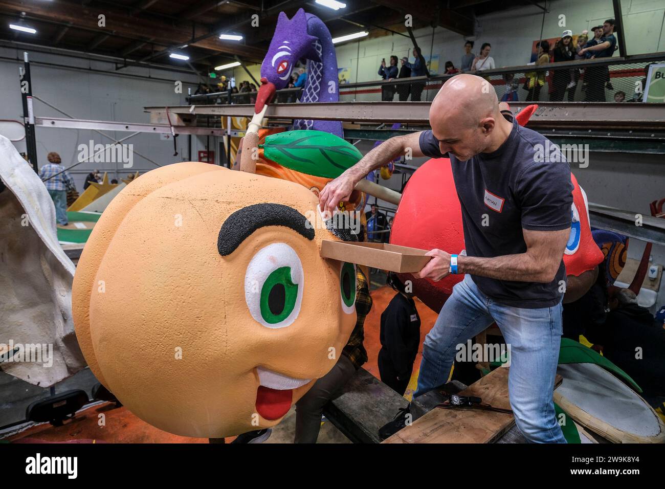 A volunteer works on a float for the 135th Rose Parade in Pasadena