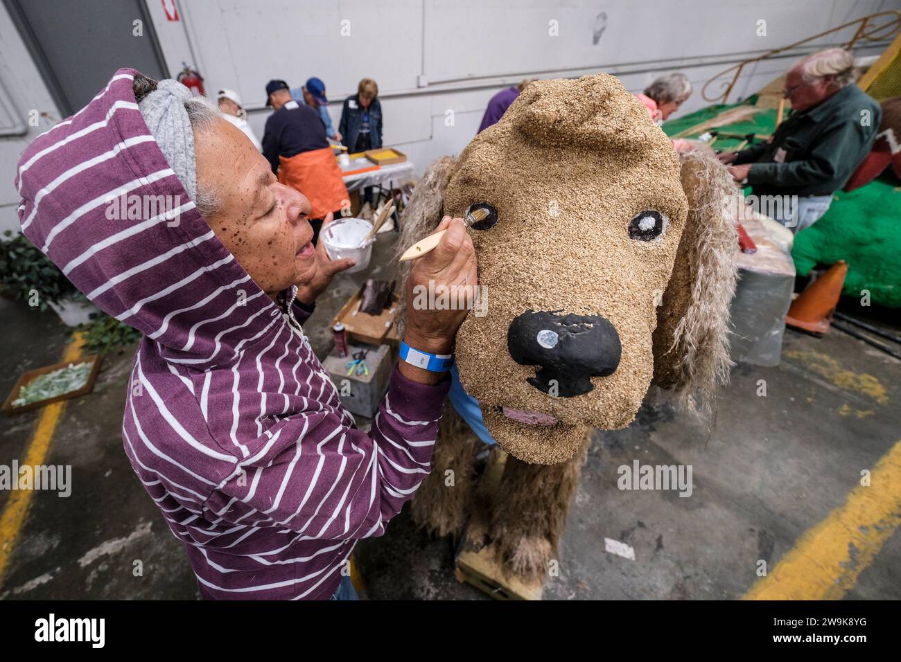 A volunteer works on a float for the 135th Rose Parade in Pasadena