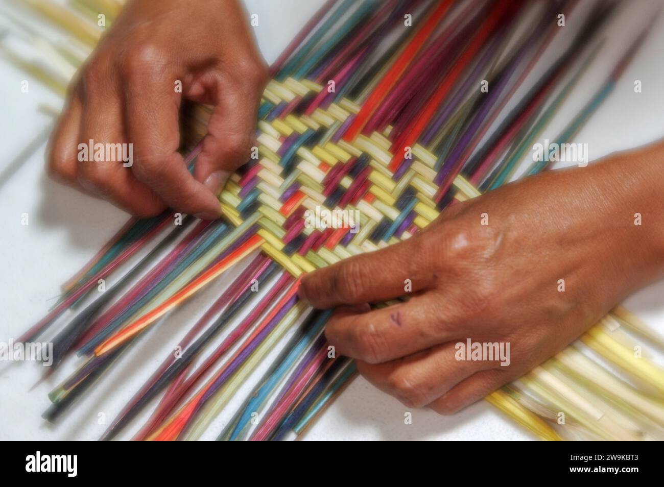 Iva Honyestewa weaves yucca fibers into a basket, Second Mesa, Hopi, Arizona Stock Photo