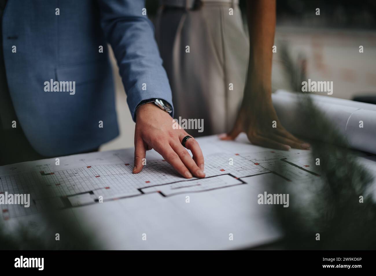 Collaborating Architects Discussing Blueprint on Construction Site Stock Photo