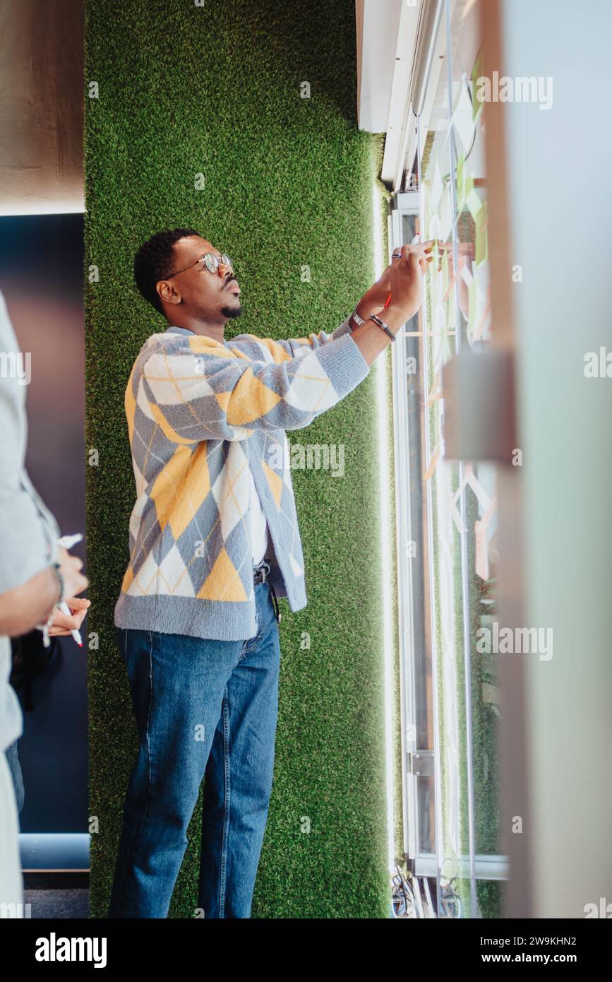 Multiracial professionals collaborate in a modern office, sharing ideas and problem-solving. Stock Photo