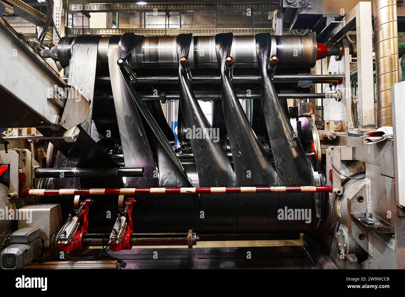 Black rubber ribbons rolled by tool at compound calendering Stock Photo ...
