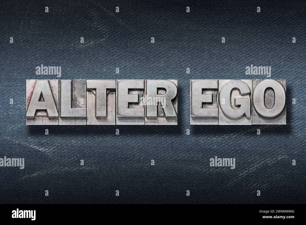 alter ego (second I) phrase made from metallic letterpress on dark jeans background Stock Photo
