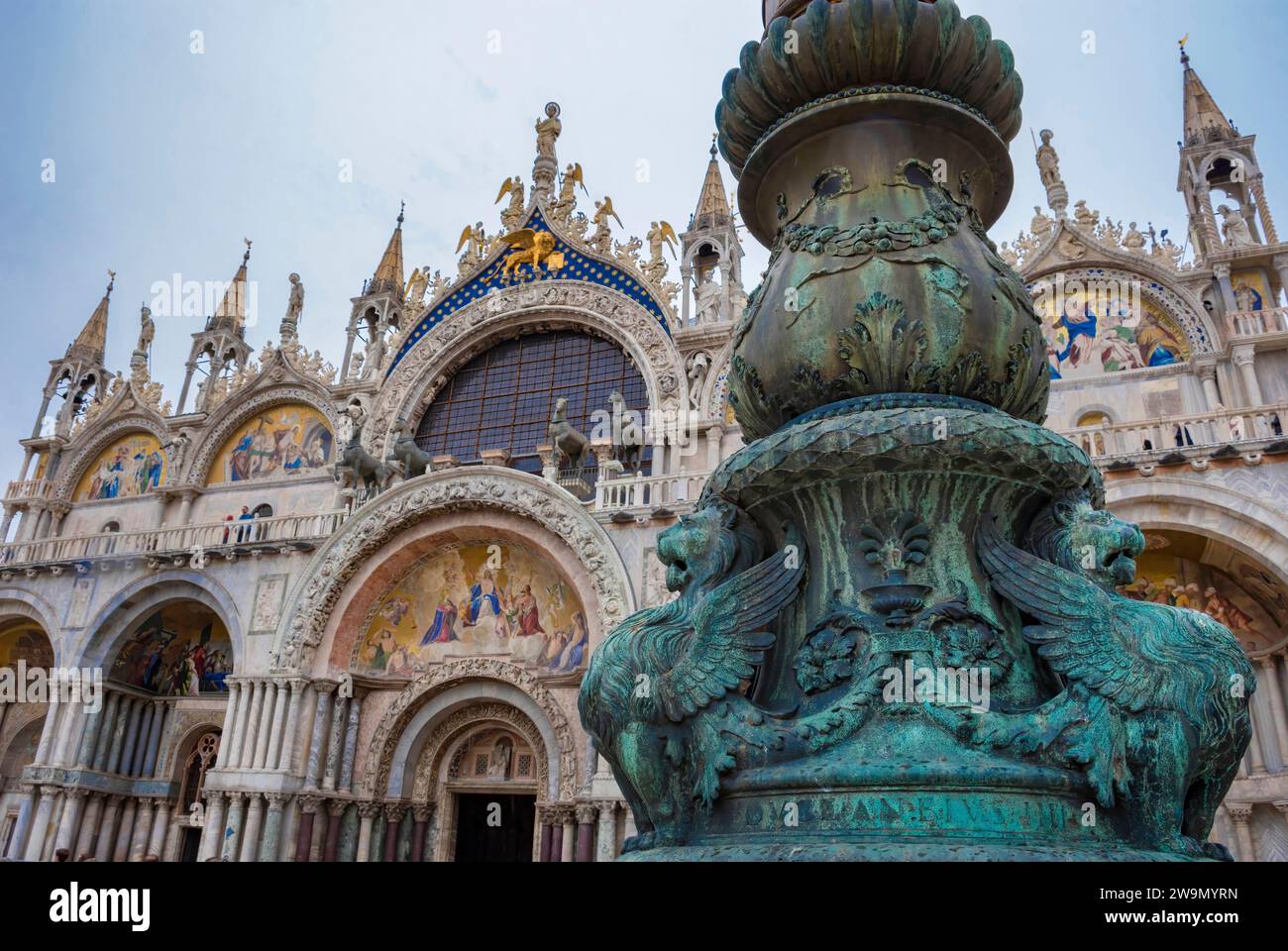 Old street ornament with winged lions and San Marco Basilica in the background, in St. Mark Square, famous tourist attraction in Venice, Italy. Select Stock Photo