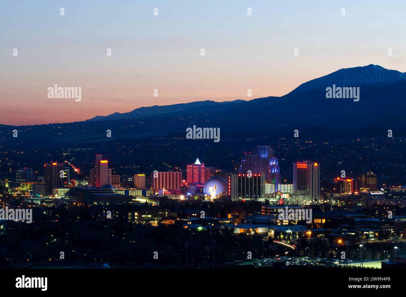 Reno nevada mountain silhouette - The Reno Skyline Is Illuminated At Dusk Against The Backdrop Of The Sierra Nevada Mountains Nevada 2W9N4F8
