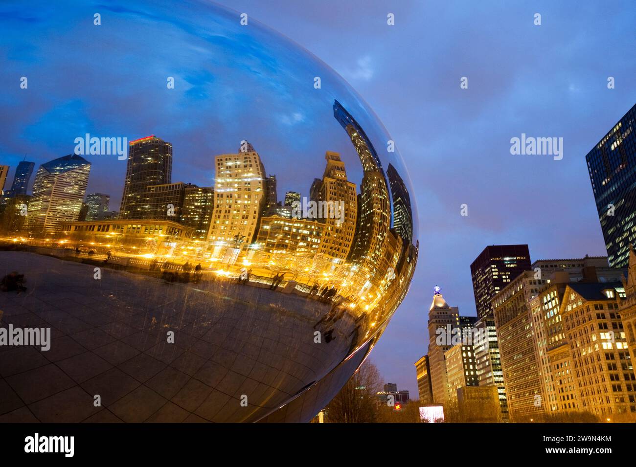 The Chicago skyline is reflected at dusk in the Cloud Gate sculpture ...