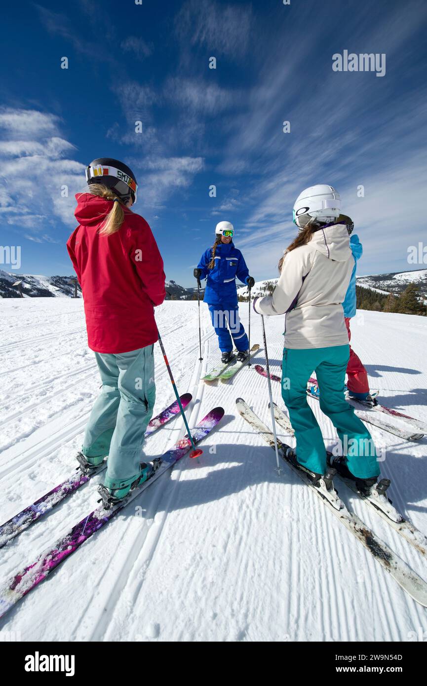 A group of women gather around and listen to their ski instructor in the winter at Kirkwood Mountain Resort in Kirkwood, California. Stock Photo