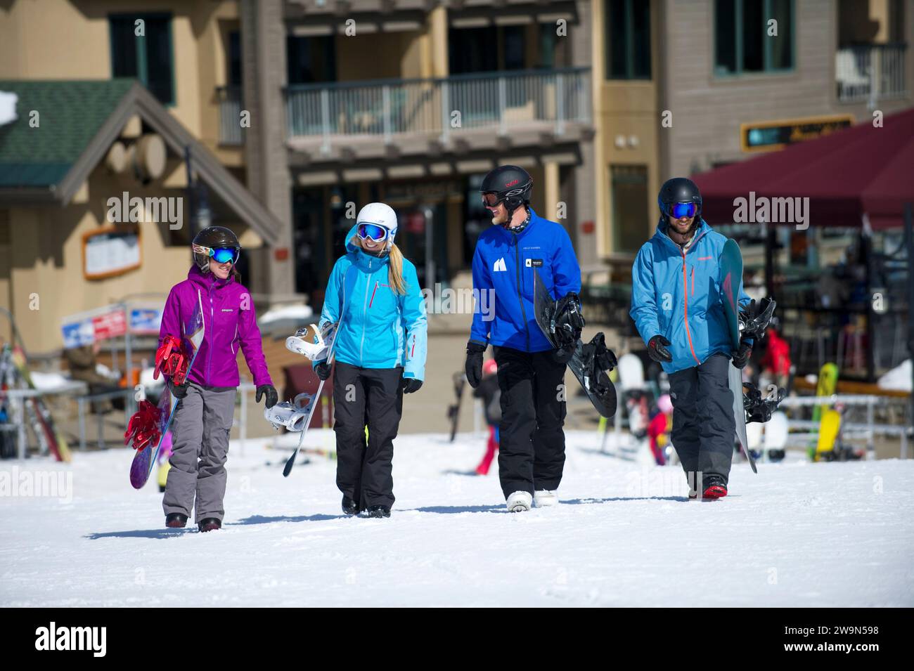 A group of snowboarders walk with their snowboard instructor in the village at Kirkwood Mountain Resort in Kirkwood, California. Stock Photo