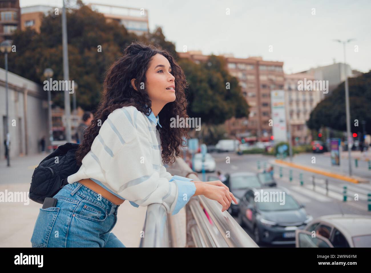 South American woman with curly hair looking towards the city Stock Photo