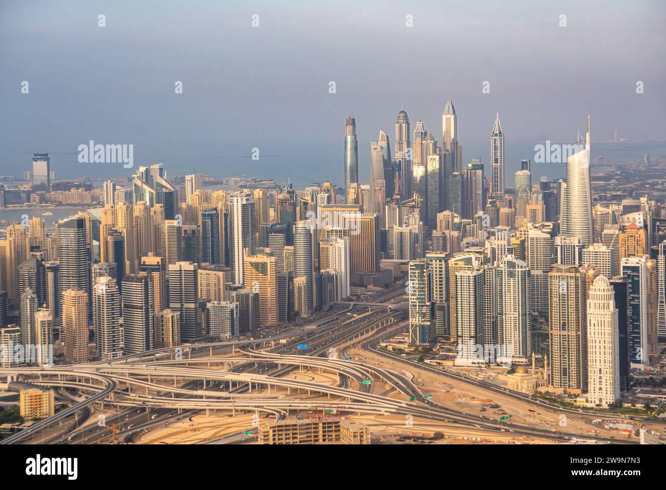 Aerial view of Dubai Marina, UAE, with many tall skyscrapers and the Sheikh Zayed road. Traffic, transportation, pollution and hazy sky. Stock Photo