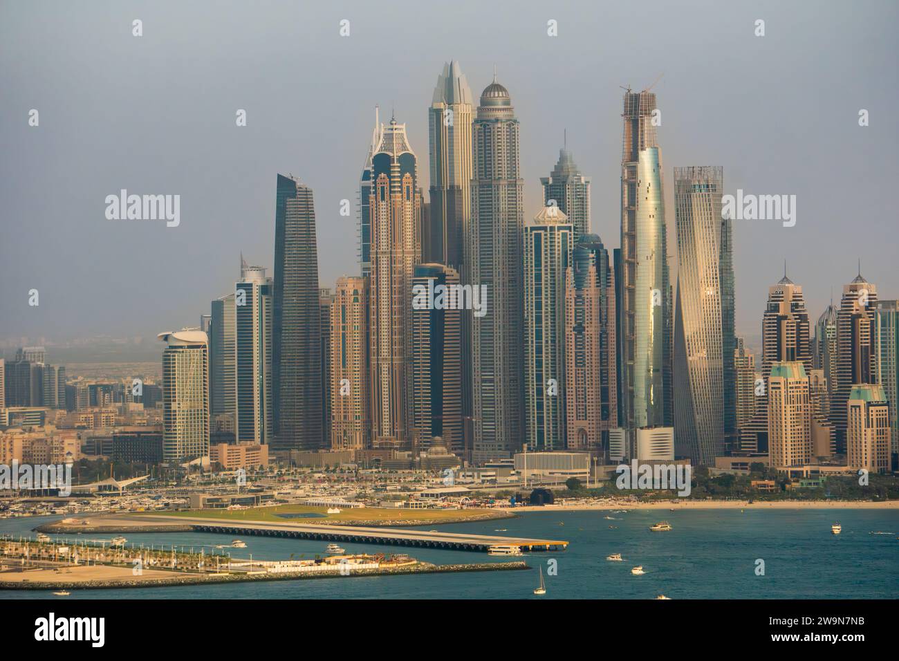 Aerial view of the Dubai Marina distric, UAE, with many tall skyscrapers and hotels. Hazy pollution in the sky. Futuristic buildings. Stock Photo