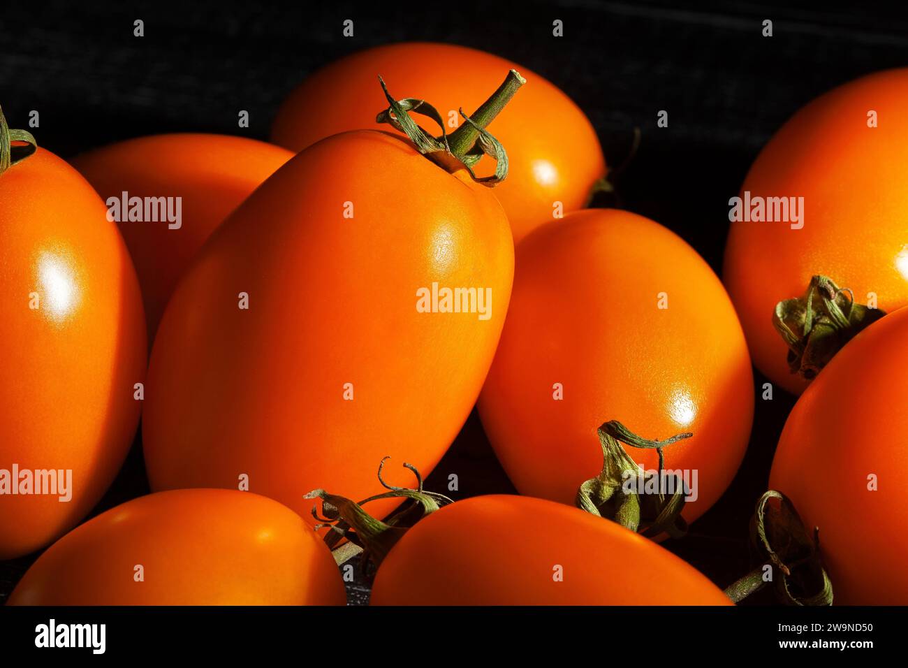 orange plum tomato on black background Stock Photo