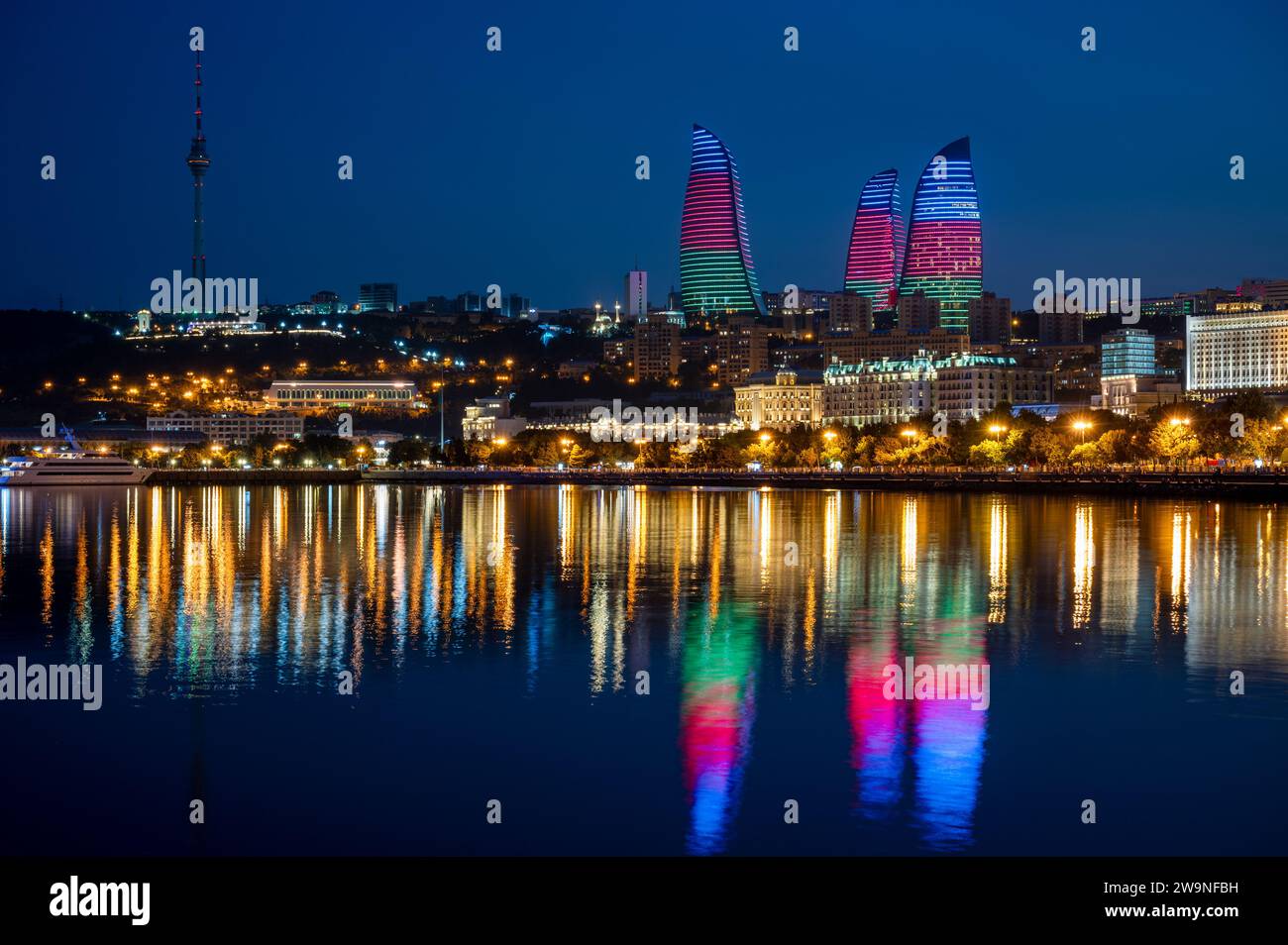 Night view of the the skyline of Baku, capital city of Azerbaijan with reflection of the Flame Towers in the waters of the Caspian Sea. Stock Photo