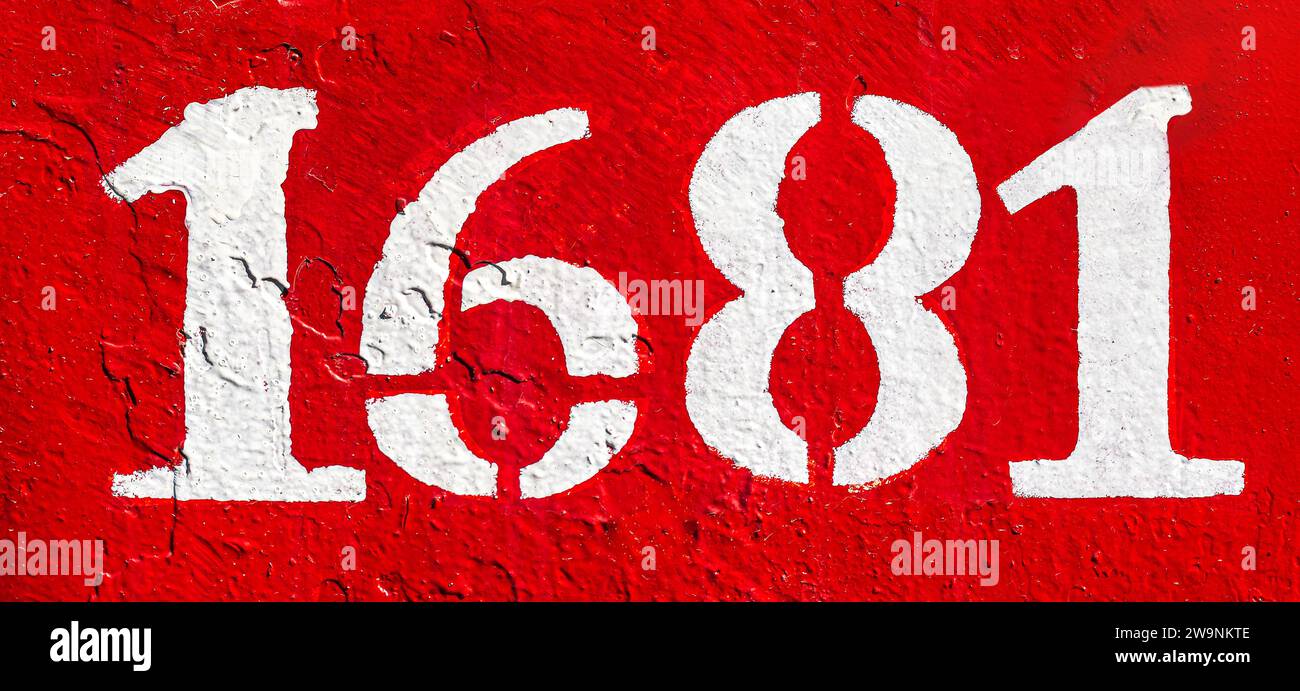 Weathered numbers one, six, eight, 1681, or 1, 6, 1 painted white on a