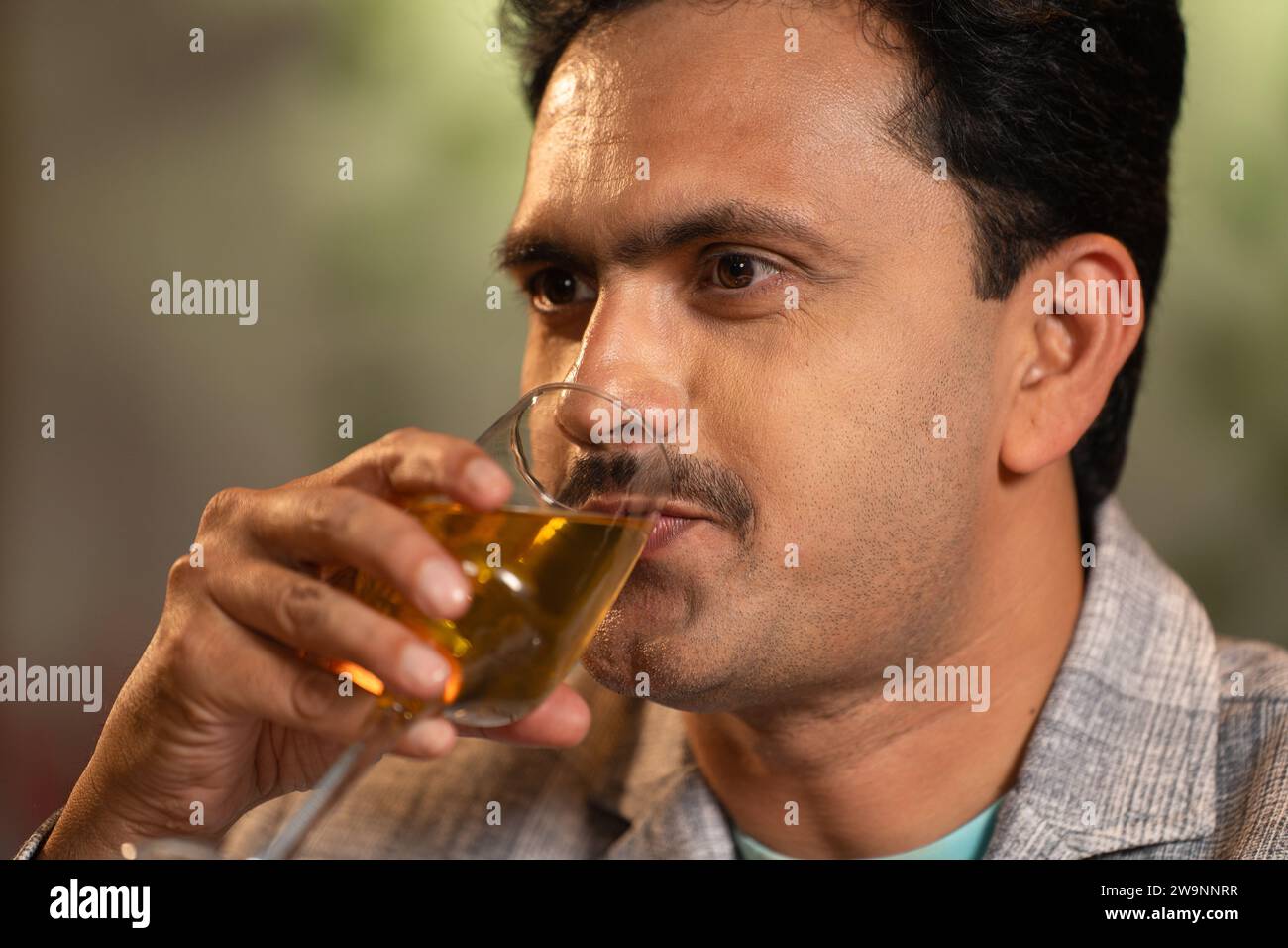 Close up shot of middle aged Indian man drinking wine at weekend night party at restaurant - concept of luxury lifestyles, refreshment and relaxation Stock Photo