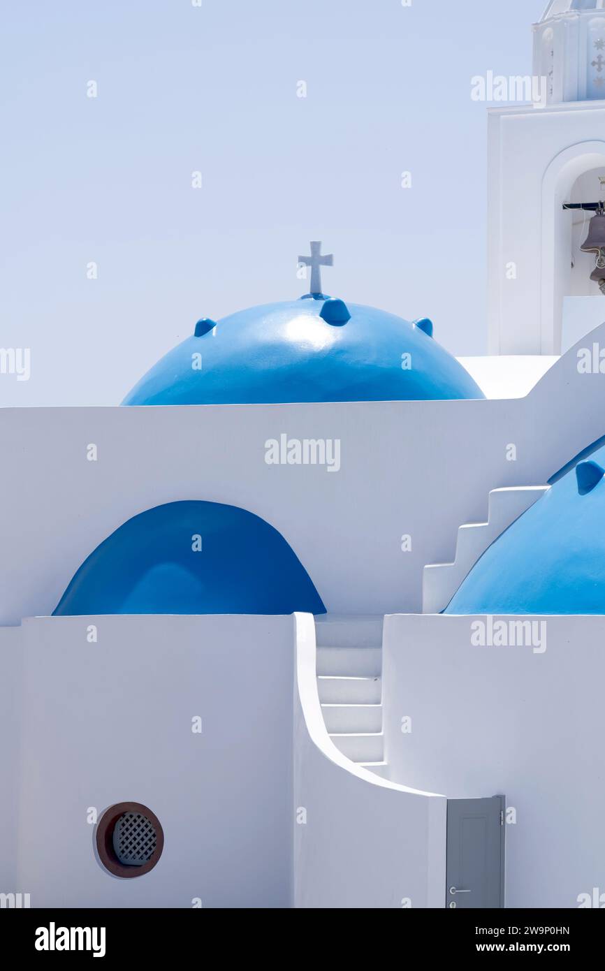 Typical architecture of Cyclades islands, with white washed structures, abstract curves and the typical blue domes of the churches, here in Therasia. Stock Photo