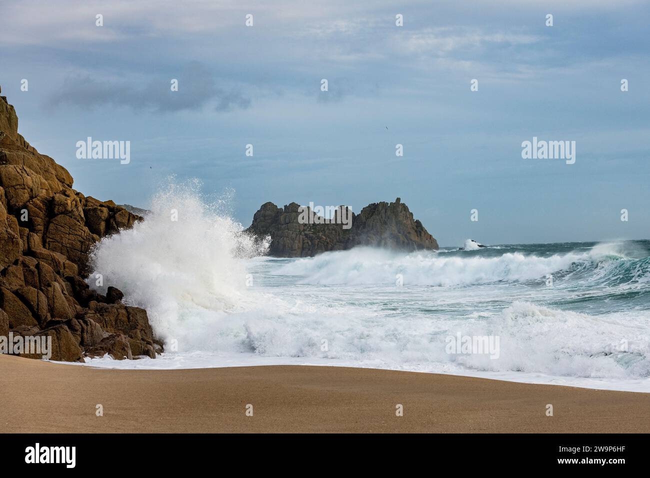 big-waves-breaking-on-porthcurno-beach-cornwall-with-the-logan-rock