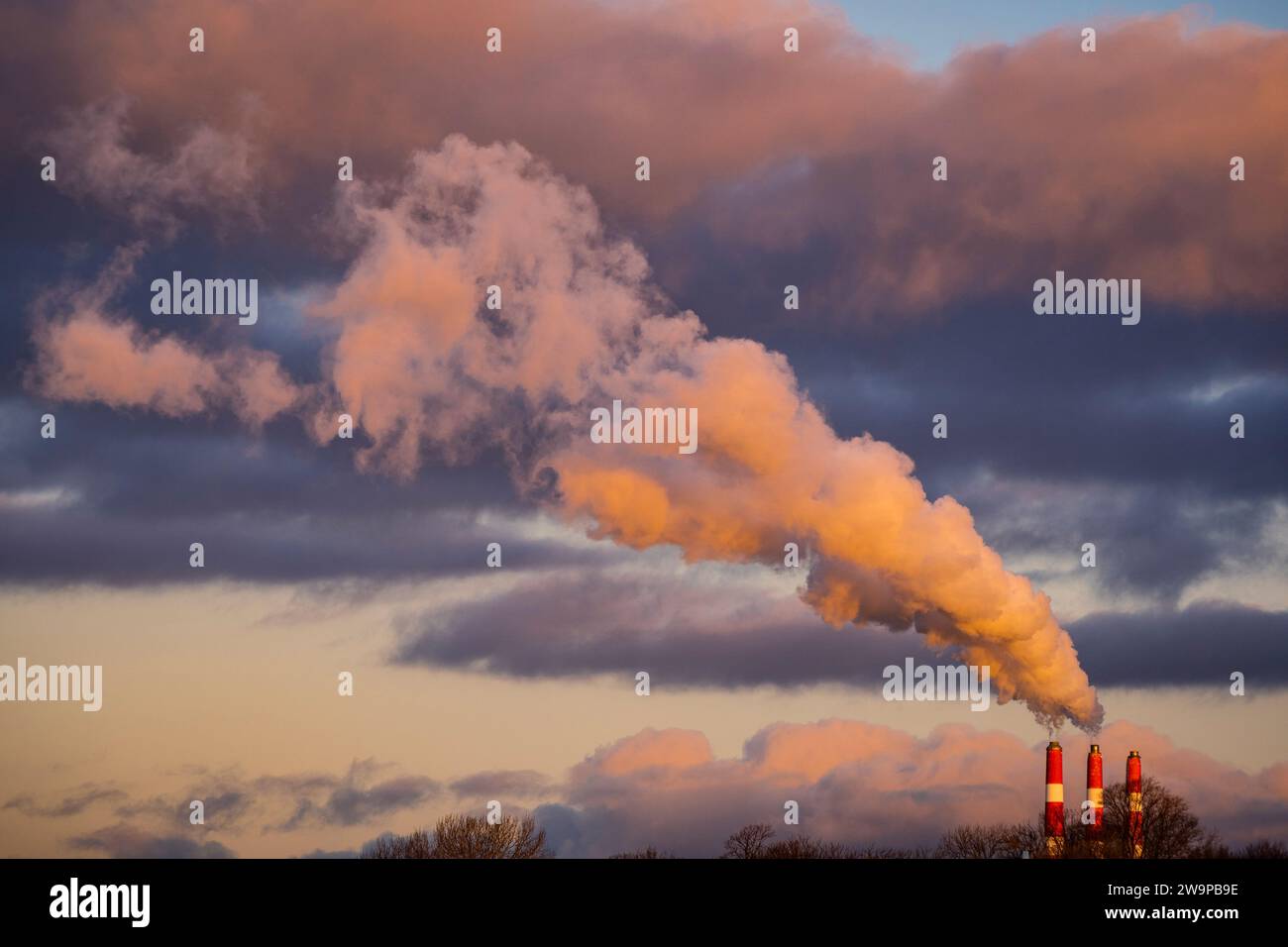 A large plume emitting to the sky from three smoke stacks. Stock Photo