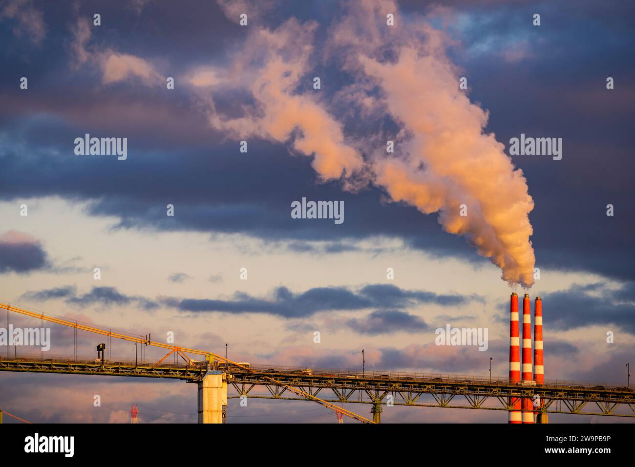 A large plume emitting to the sky from three smoke stacks. Stock Photo