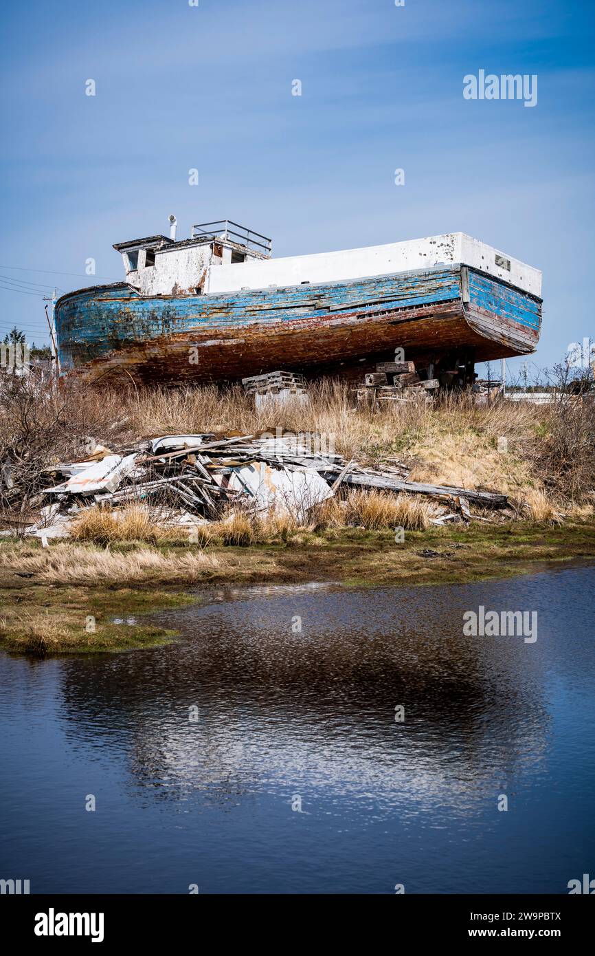 Abandoned wooden fishing boat slowly rotting away on the Eastern Shore of Nova Scotia, Canada. Stock Photo