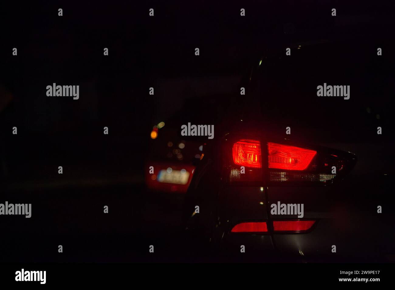 Taillights shining bright in the night traffic, a mesmerizing scene of urban motion. Stock Photo