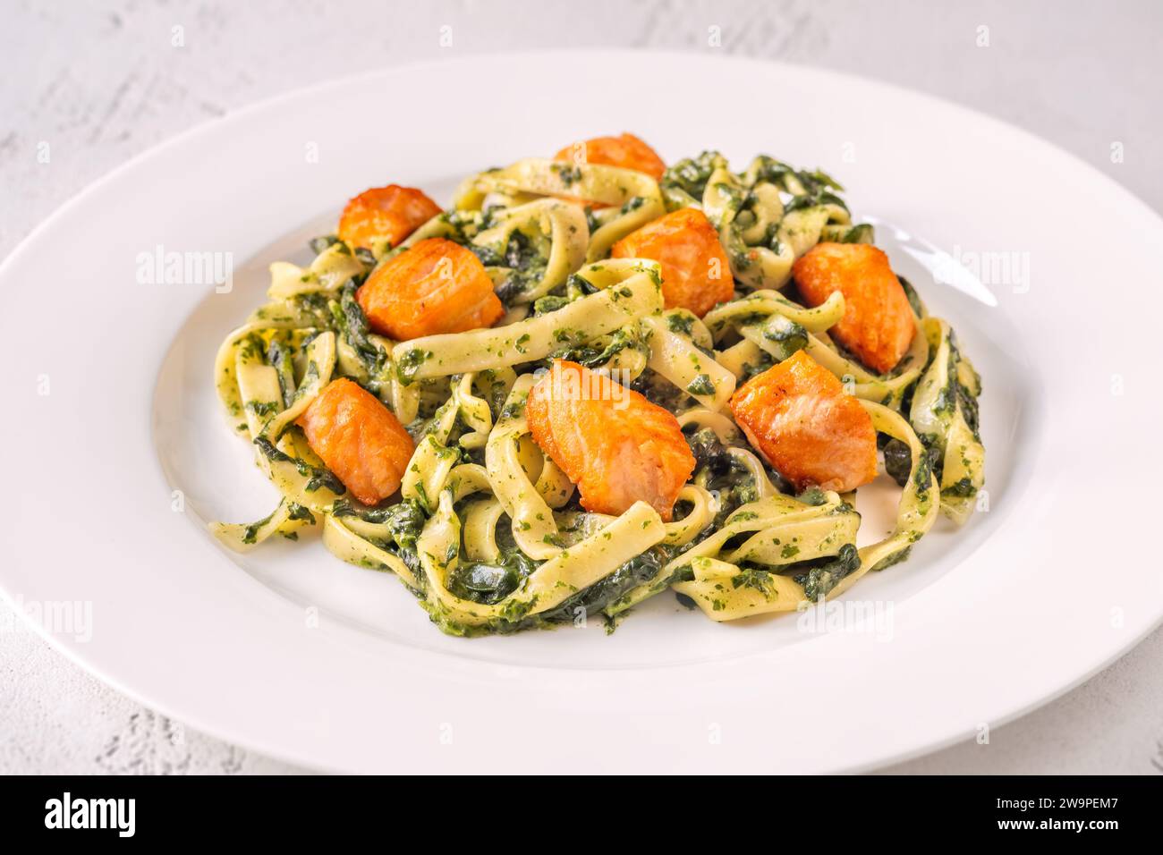 Portion of creamy spinach pasta with salmon Stock Photo