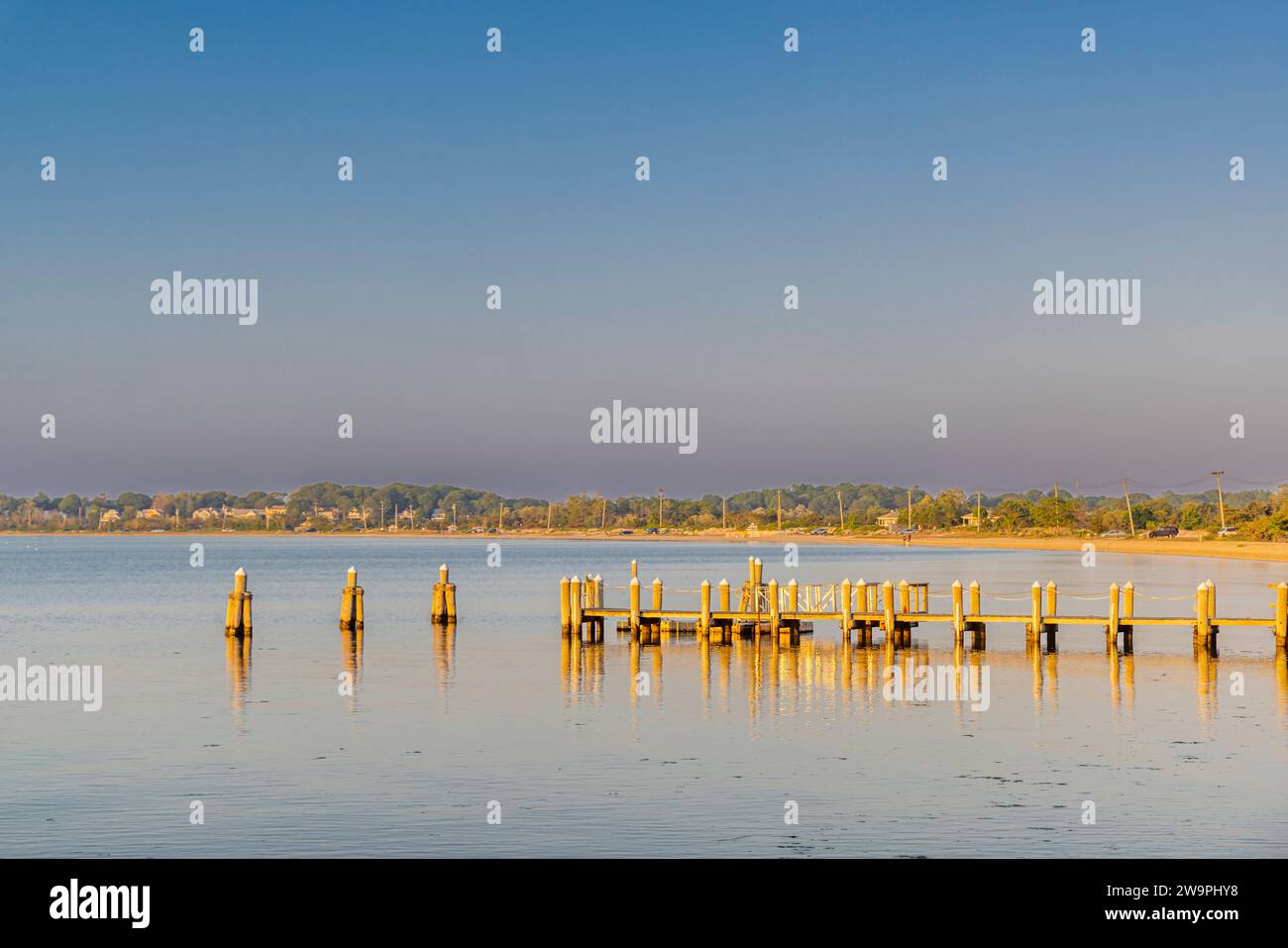 image of a dock and long beach in the distance Stock Photo