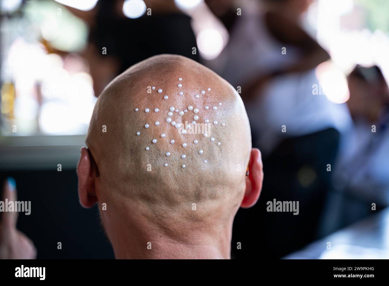 08.07.2023, Berlin, Germany, Europe - Close-up of the back of the head decorated with beads of a techno music enthusiat at the 2023 'Rave the Planet'. Stock Photo