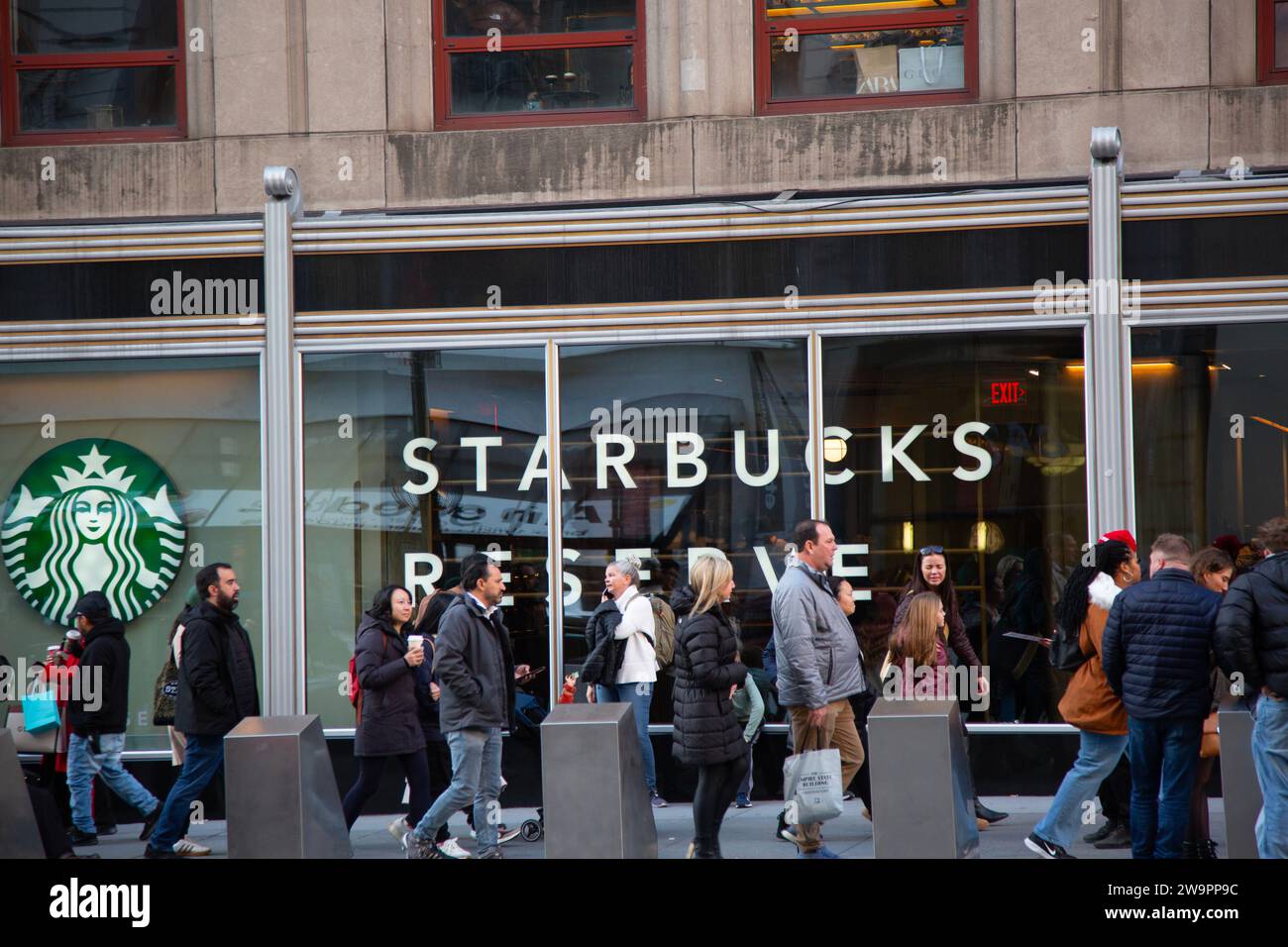 People walk by Starbucks along 5th Avenue  near 34th Street in Manhattaan, New York City Stock Photo
