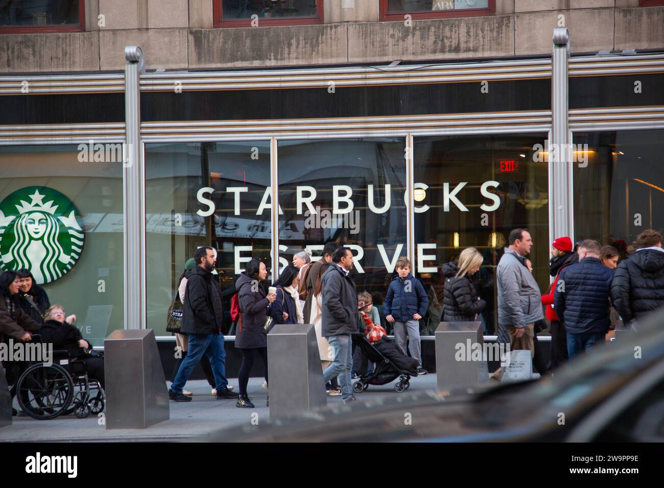 People walk by Starbucks along 5th Avenue  near 34th Street in Manhattaan, New York City Stock Photo
