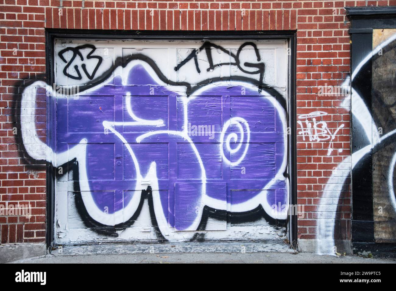 Graffiti on garage roll up door in downtown Montreal, Quebec, Canada Stock Photo