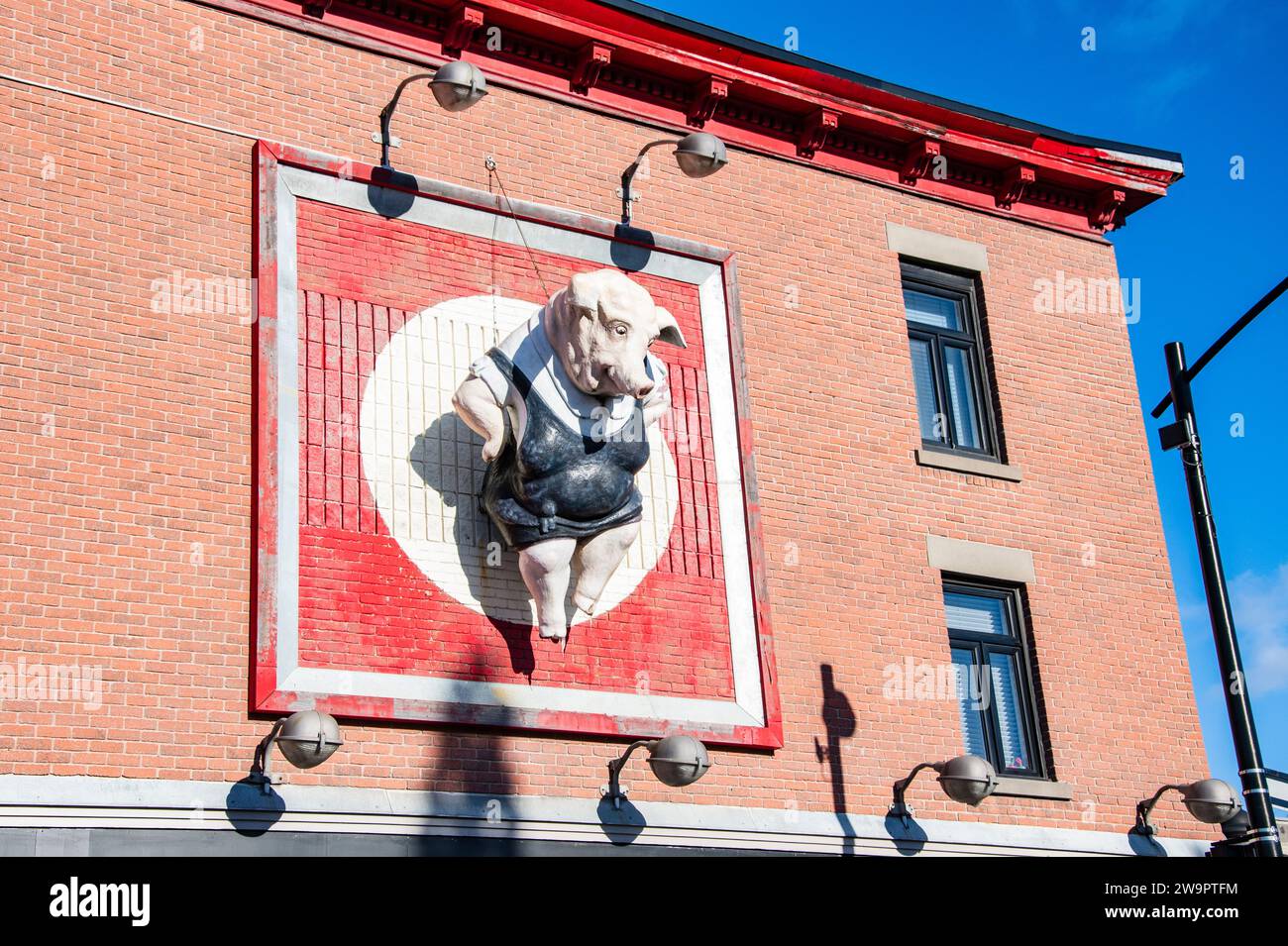 Sculpture of a pig wearing a black apron sign at a butcher shop in downtown Montreal, Quebec, Canada Stock Photo