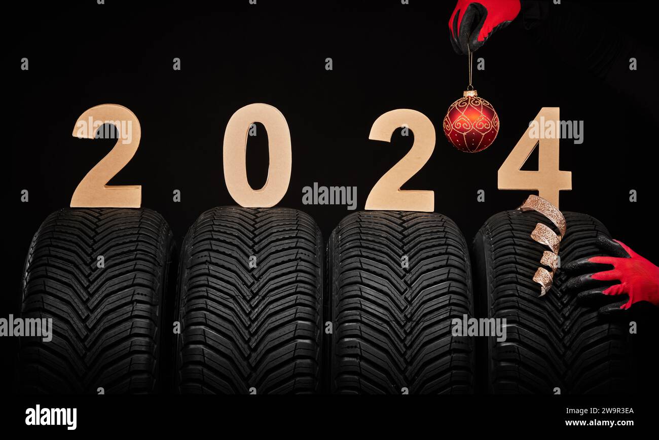 Winter car tires service hand with christmas ball and text happy new